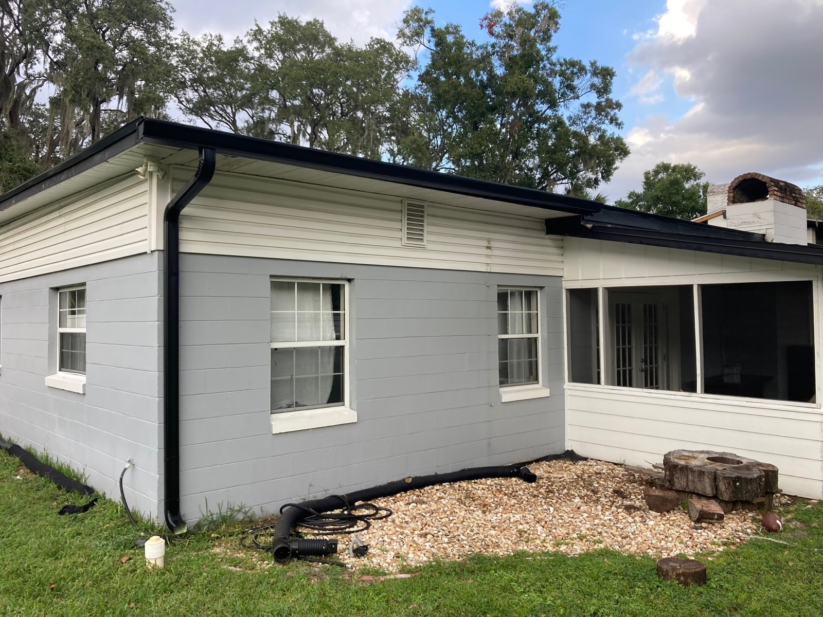 Gray Florida home with black seamless gutters and downspouts